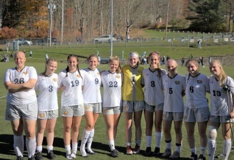 The 10 seniors of the Women’s Soccer Team posing for a photo on Senior Day. Photographed from left to right: Em Marlay-Wright, Katelyn Piccolo, Savanna Amaral, Sophie Elser, Sarah Tomczyk, Jillian Currier, Claudia Bresett, Jess Halverson, Skyelyn Haynes, and Alyssa Porter. (photo from MCLA Athletics)