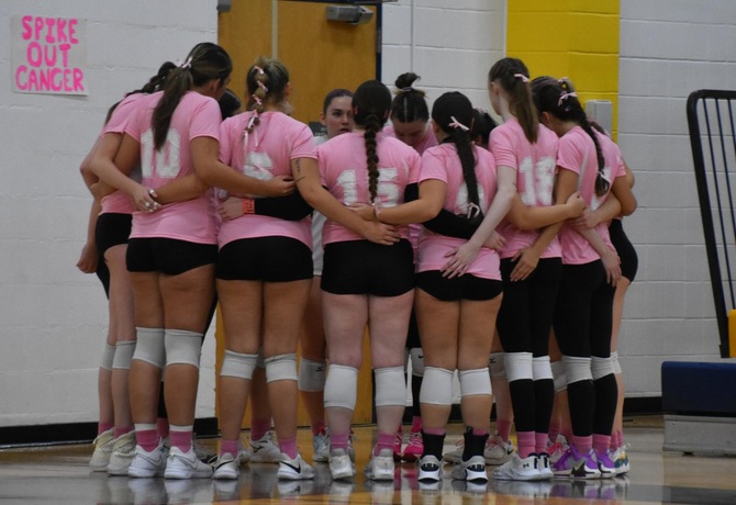 MCLA women's volleyball huddles up.